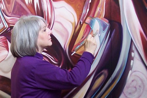 Woman in violet painting with paint brush